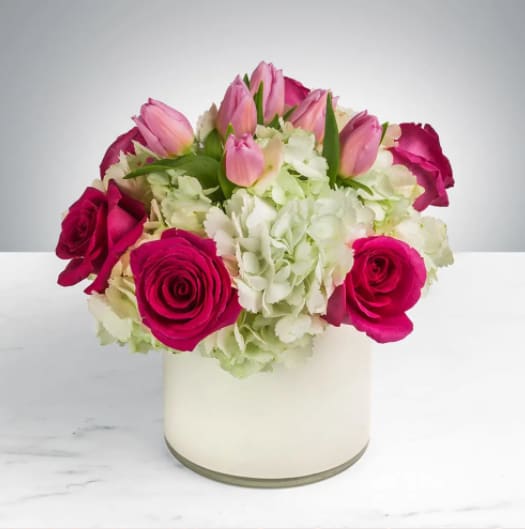 Fun &amp; Flirty by BloomNation™ - This cheerful bouquet brings lighthearted fun to any occasion. Fun &amp; Flirty by BloomNation™ is the perfect gift to wish someone a happy birthday or to say thank you.   Arrangement Details: Includes hot pink roses, pink tulips, and white hydrangea. APPROXIMATE DIMENSIONS: 12" H X 11" W 