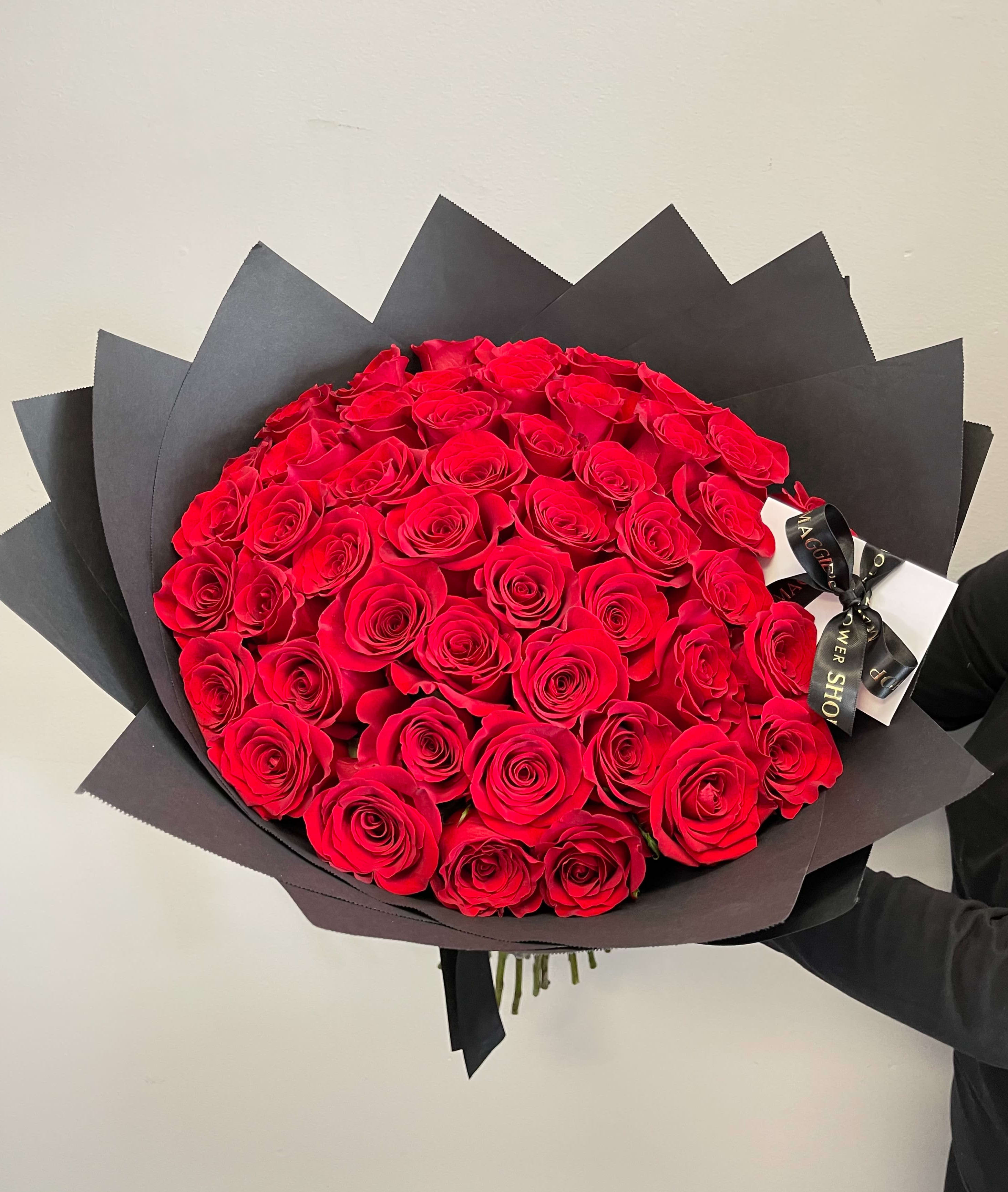 Large bouquet of red roses wrapped in black paper
