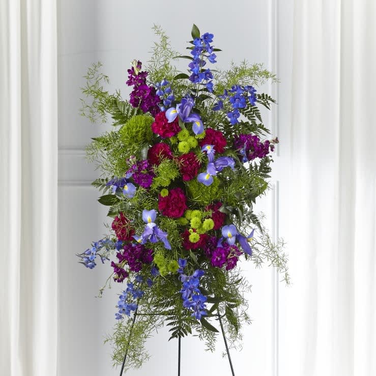 The FTD® Heavenly Skies™ Standing Spray  - This colorful spray is a modern and refreshing mix that brings serenity to those who experience a loss. Our Heavenly Skies™ Standing Spray is crafted with a beautiful blend of stock, iris, dianthus and delphinium reminiscent of a hopeful wildflower garden.    Details:  o Spray is approximately 35"H x 21"W 