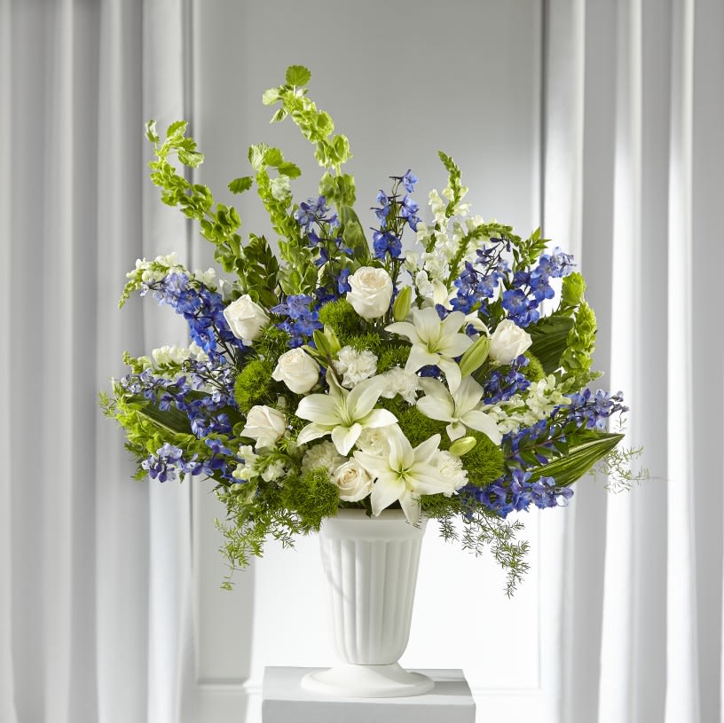The FTD® Heartfelt Hope™ Arrangement  - Our Heartfelt Hope™ Arrangement brings solace to loved ones during times of sensitivity. A local florist handcrafts a collection of lilies, roses, dianthus and delphinium to complement your calming messages of sympathy. Each bouquet comes delivered by hand and arrives fresh to a funeral home or service.   Details:  o Arrangement is approximately 29"H x 24"W 