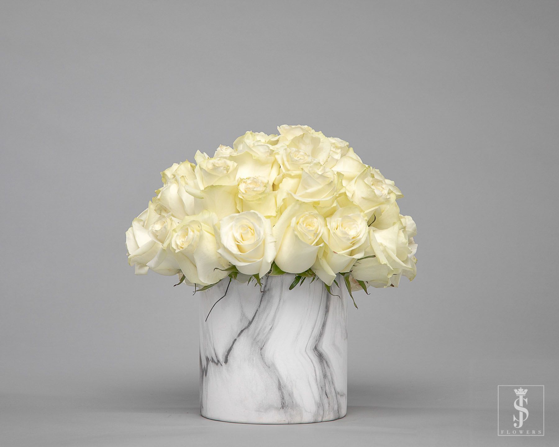White rose bouquet in a marble-patterned vase