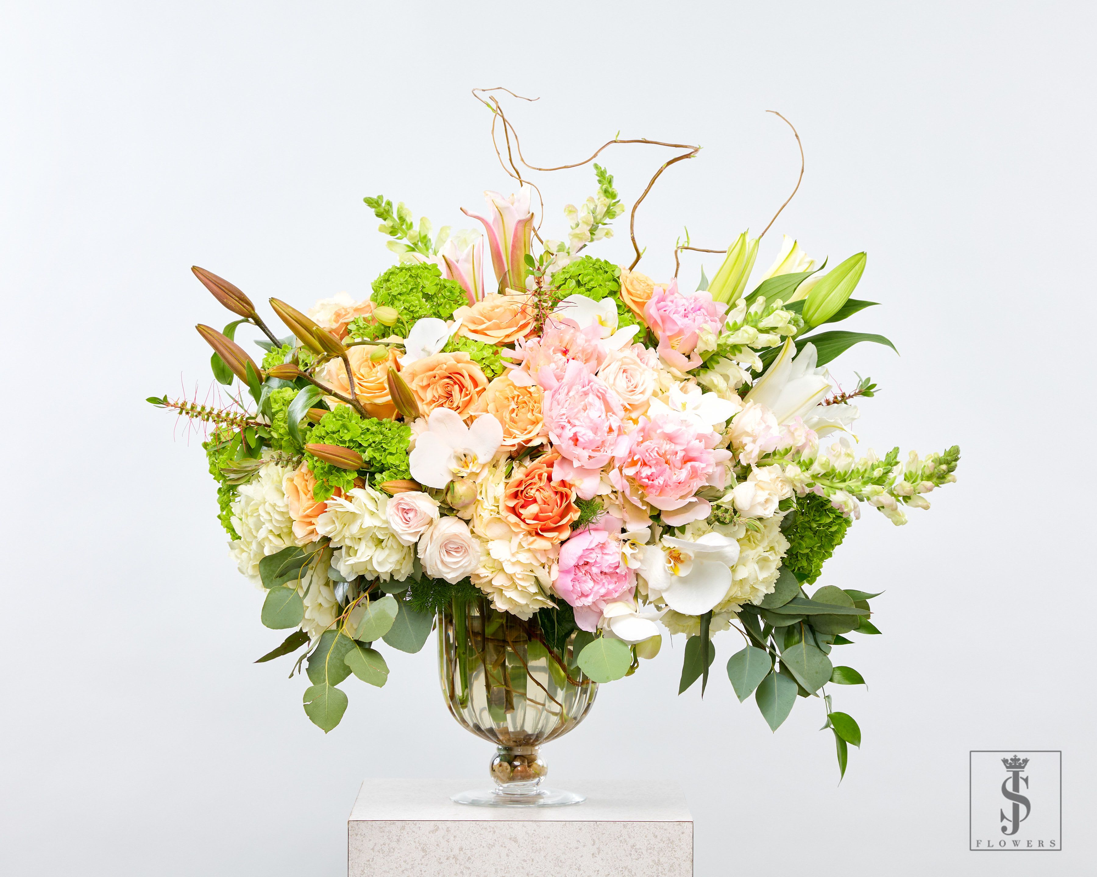 Large pastel floral arrangement in a glass vase