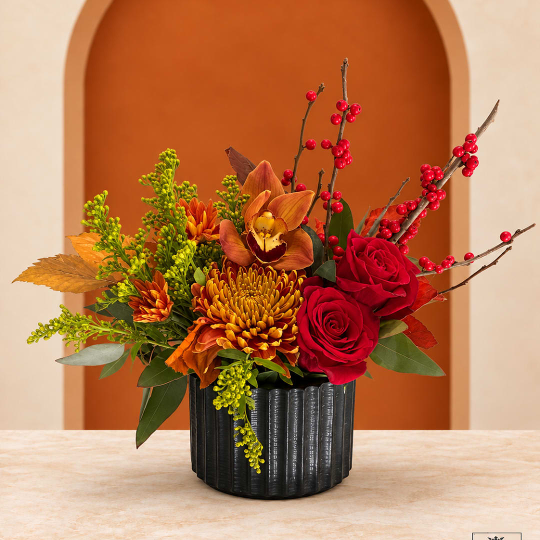 Autumn bouquet with red roses and orange flowers in a black vase