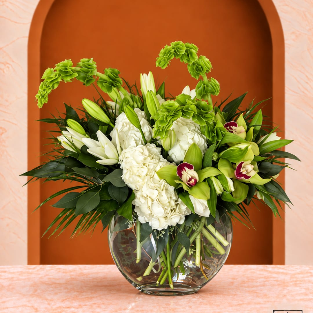 White and green floral arrangement in a clear glass vase