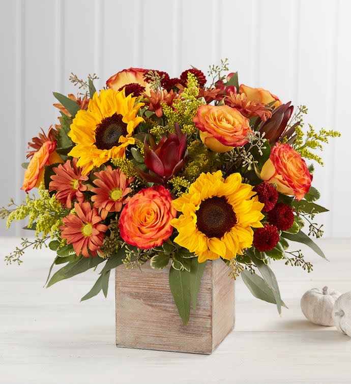 Sunflowers and orange roses in a wooden cube vase