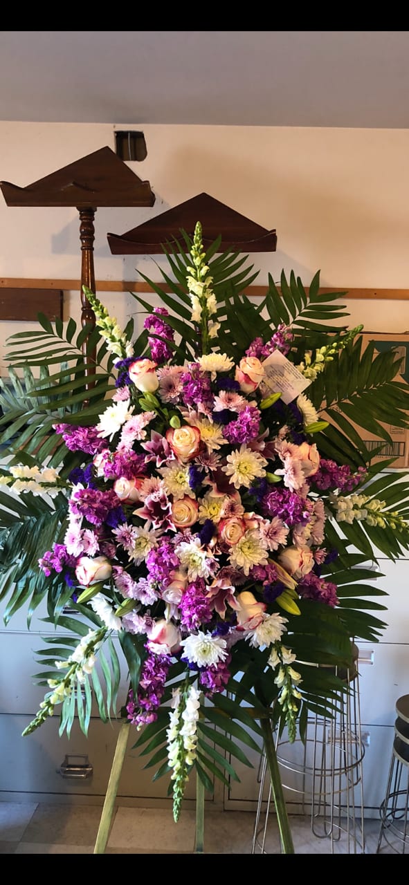 Large standing floral spray with pink, white, and purple flowers