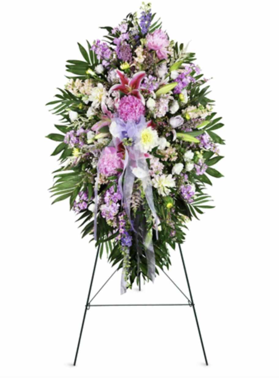 Standing floral spray with pink, purple, and white flowers on an easel
