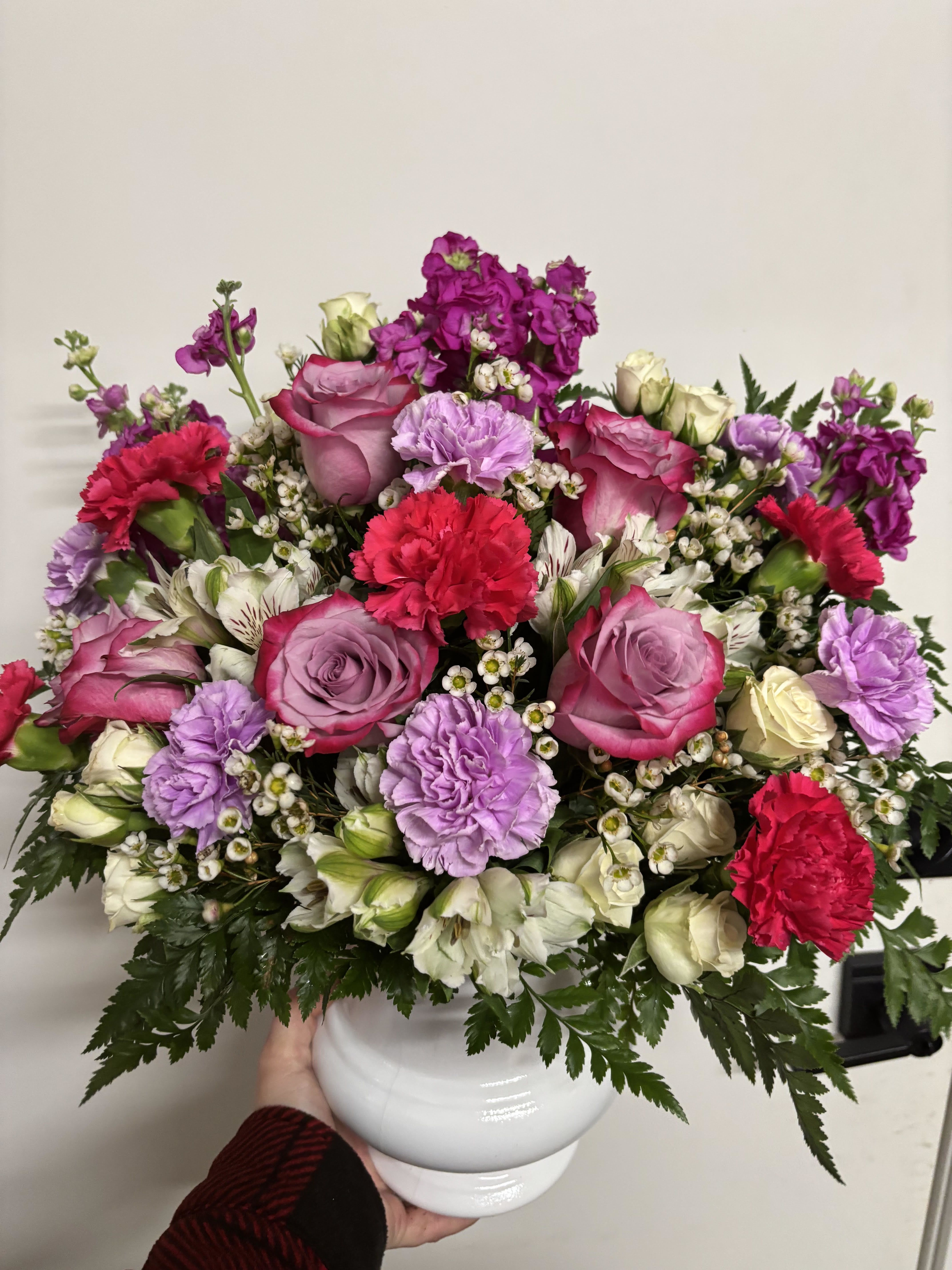 Pink and lavender flower arrangement in a white vase