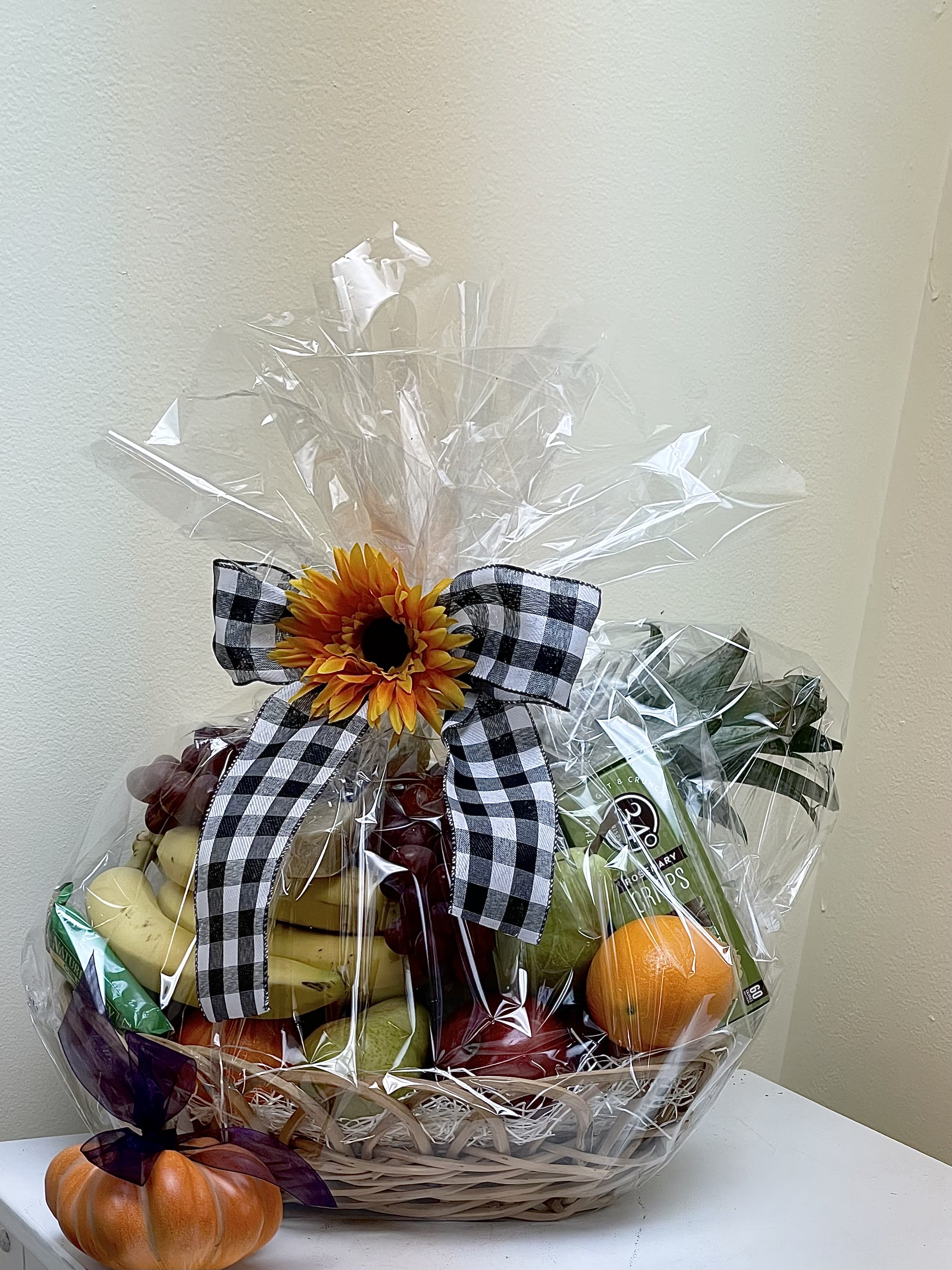 Fruit basket with a sunflower bow and a small pumpkin decoration