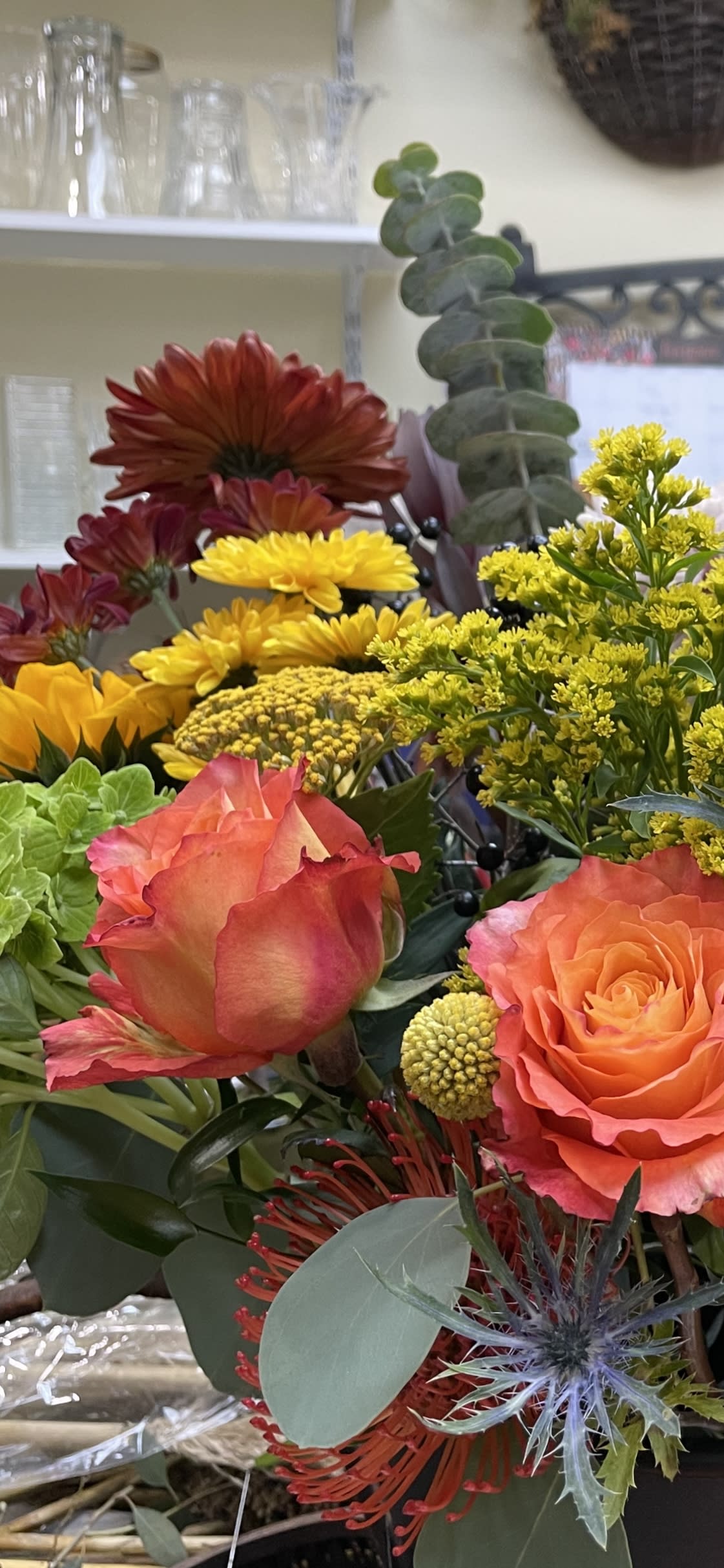 Mixed bouquet with orange roses, yellow chrysanthemums, and red blooms