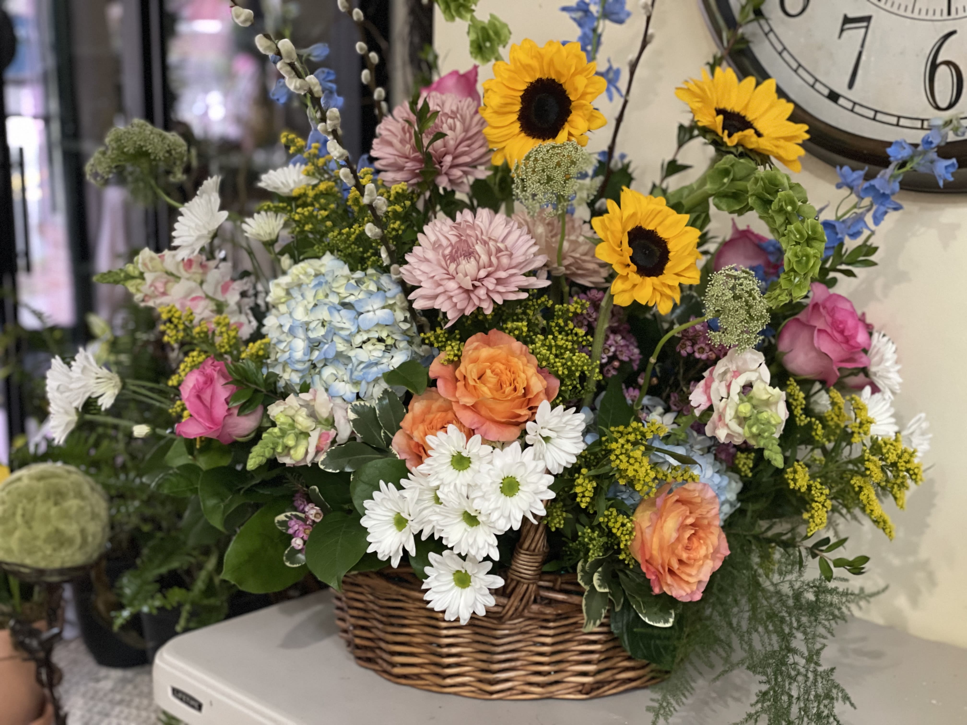Mixed flower basket with sunflowers, roses, daisies, and hydrangeas