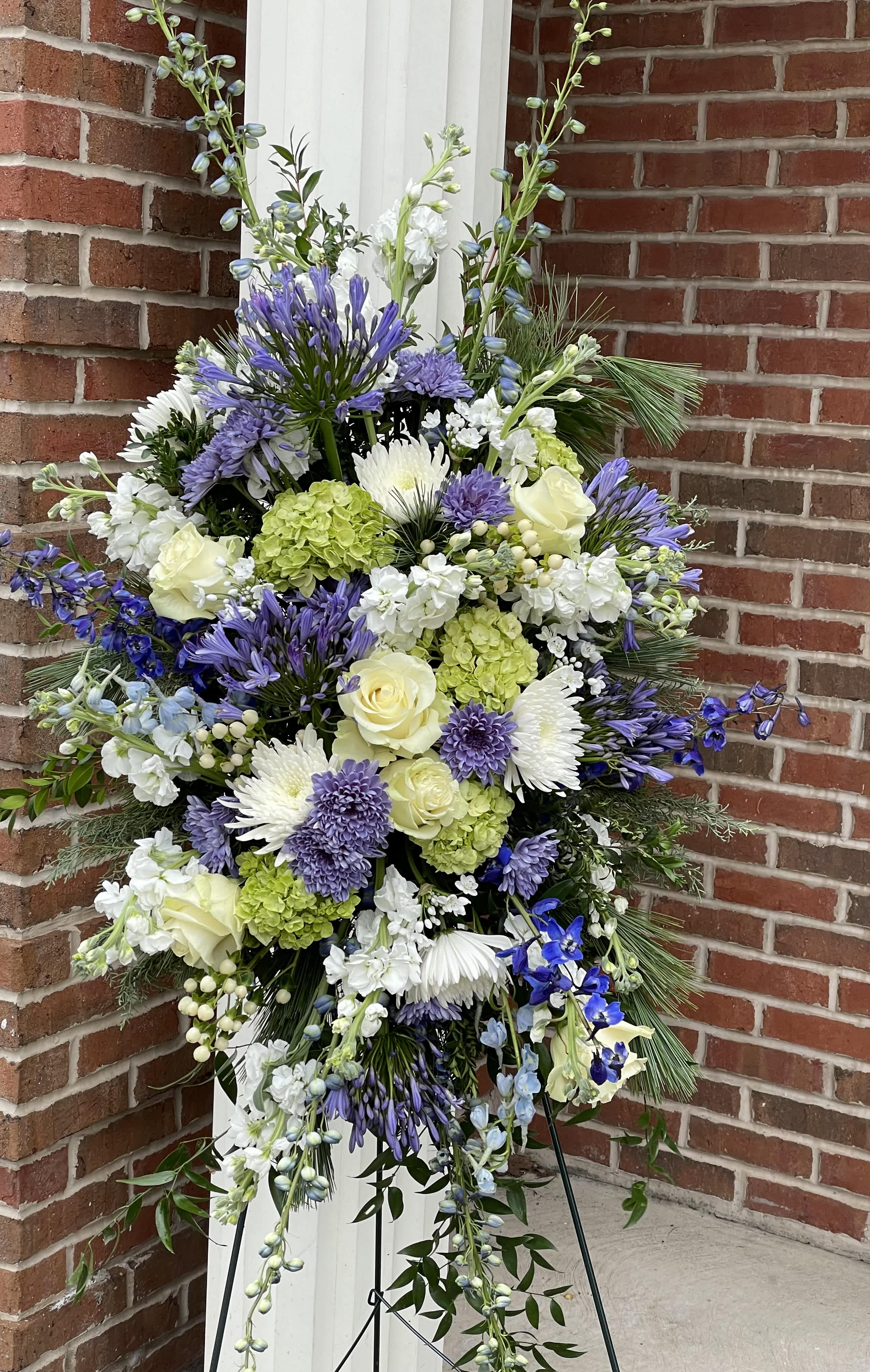 Tall standing floral spray with purple, white, and green blooms