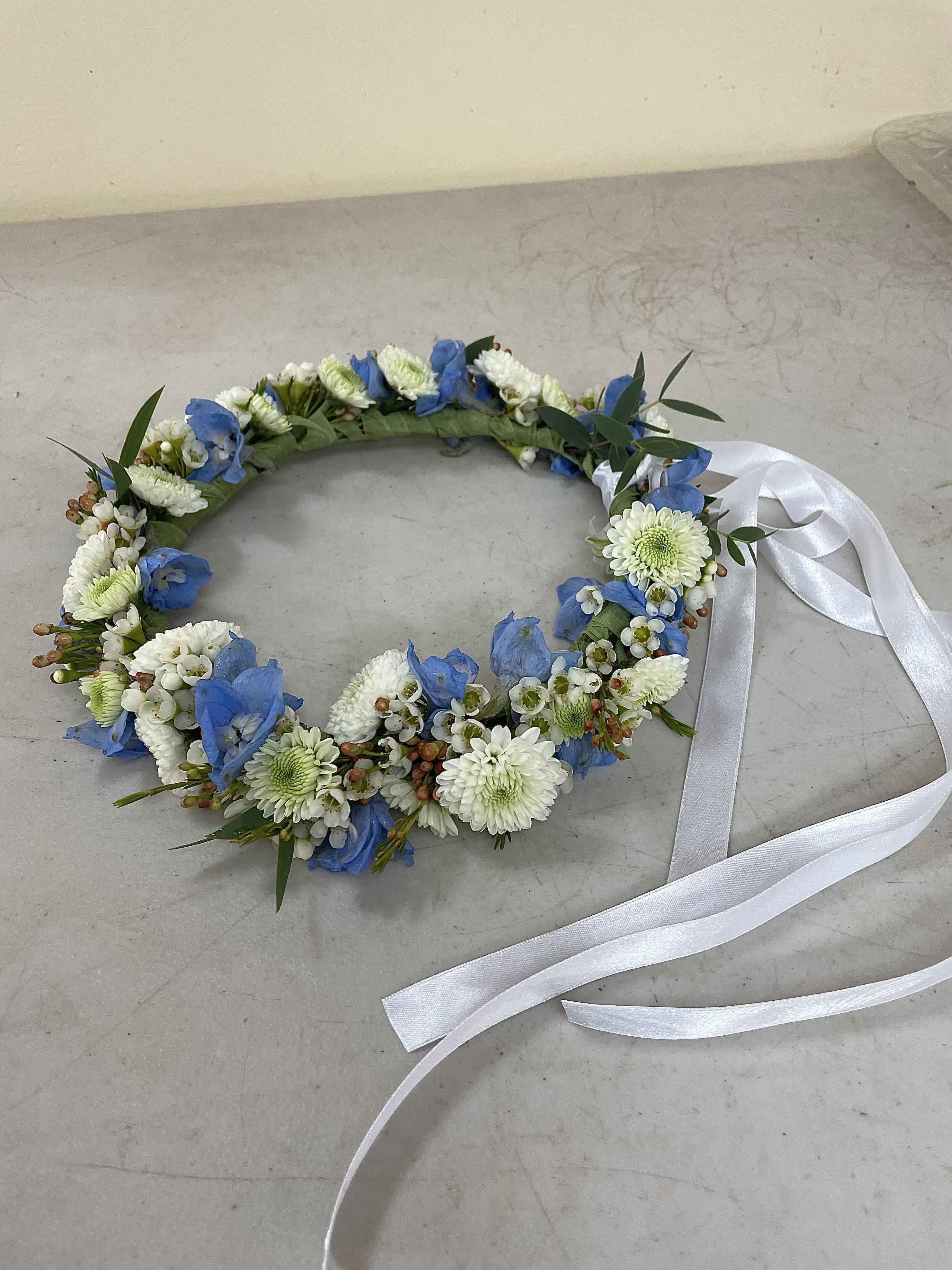 Blue and white floral wreath with a white ribbon