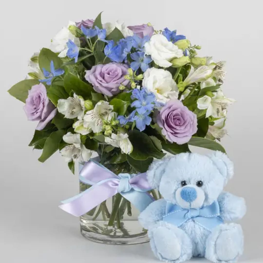 Lavender and white bouquet in a glass vase with a blue teddy bear