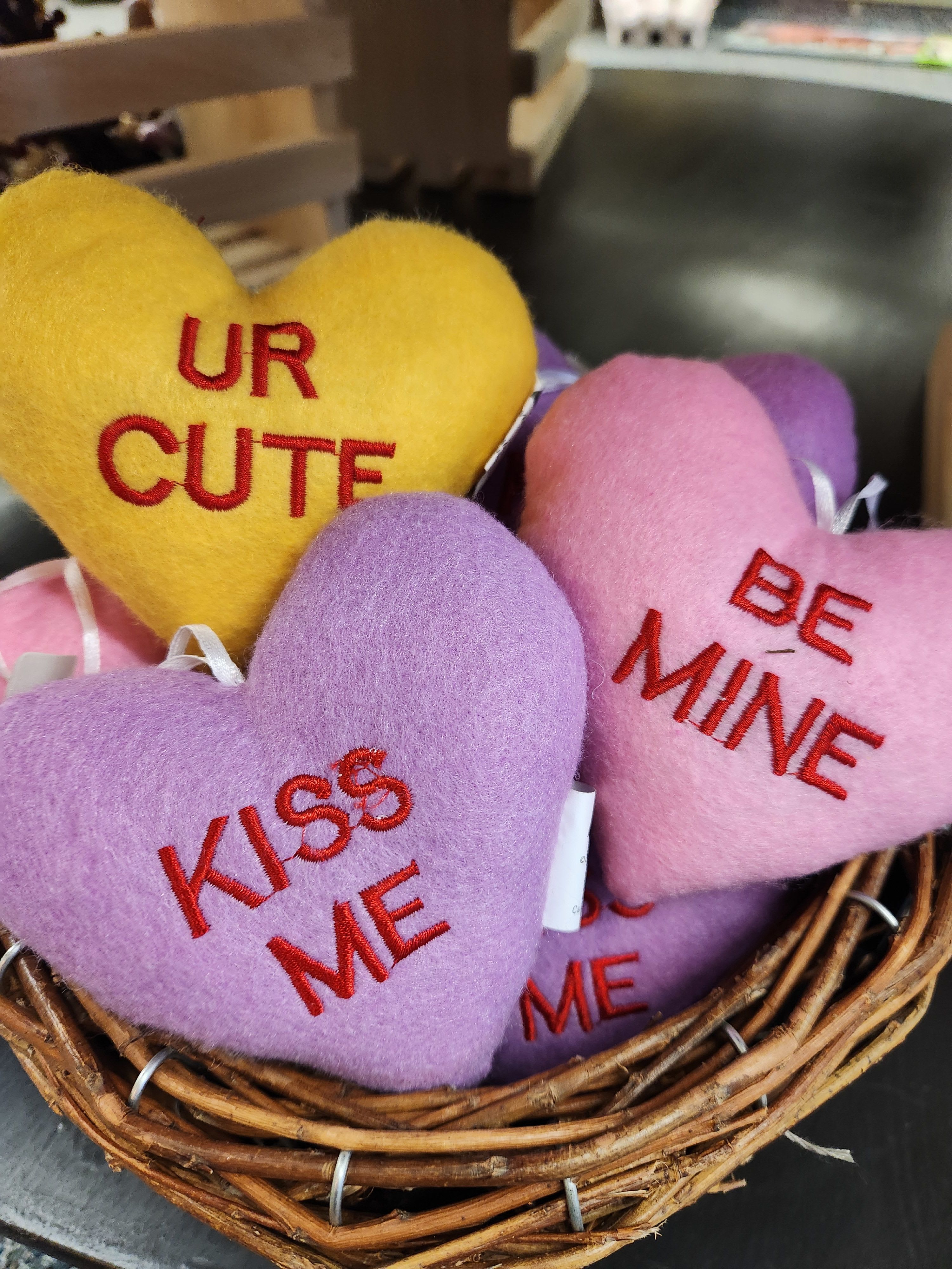 Heart-shaped plush gifts in a wicker basket with embroidered messages