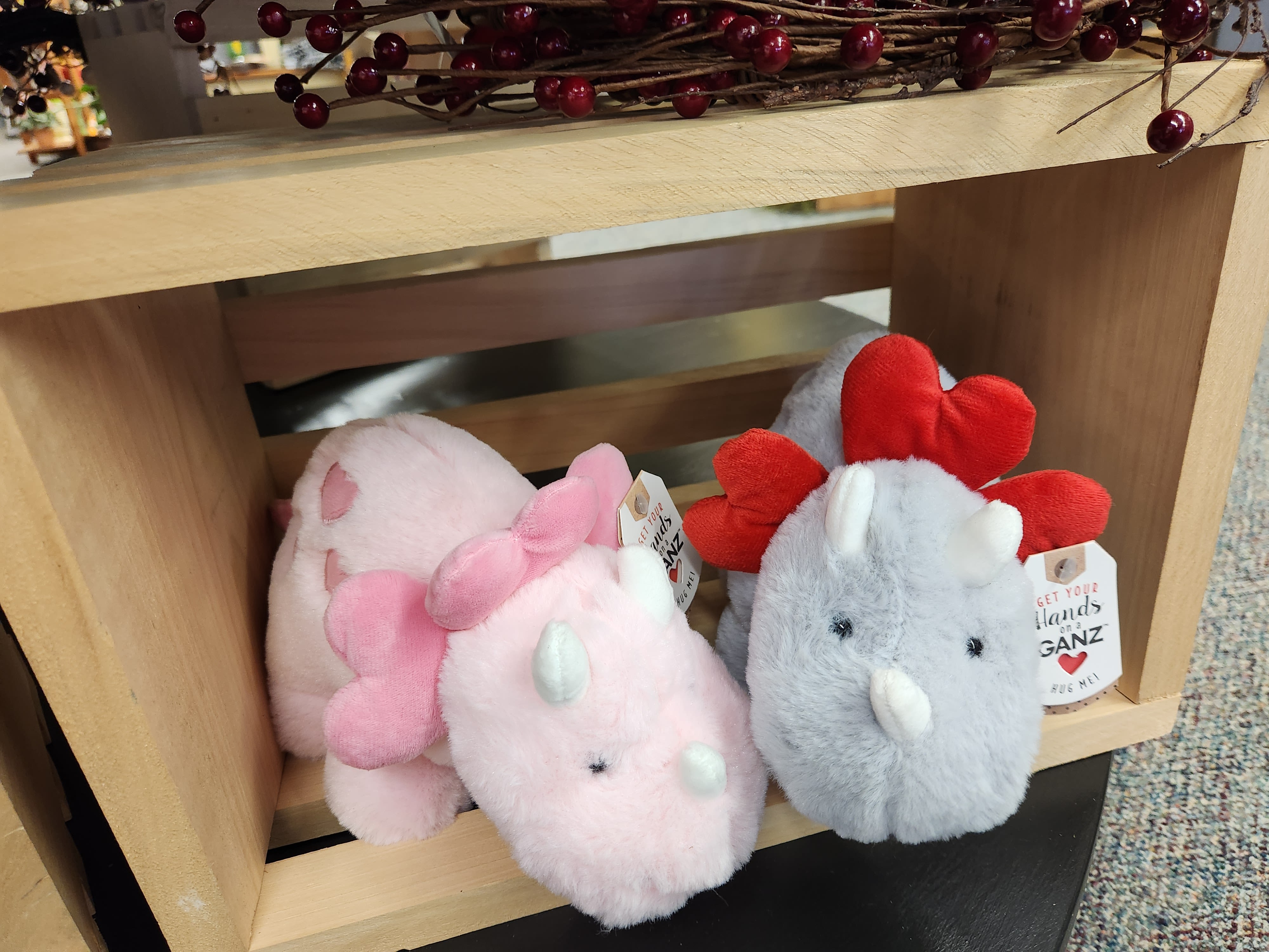 Plush dinosaur toys in pink and gray with heart-shaped spikes