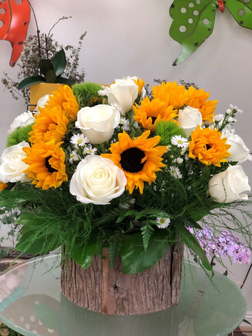Sunflower and white rose arrangement in a rustic wooden container