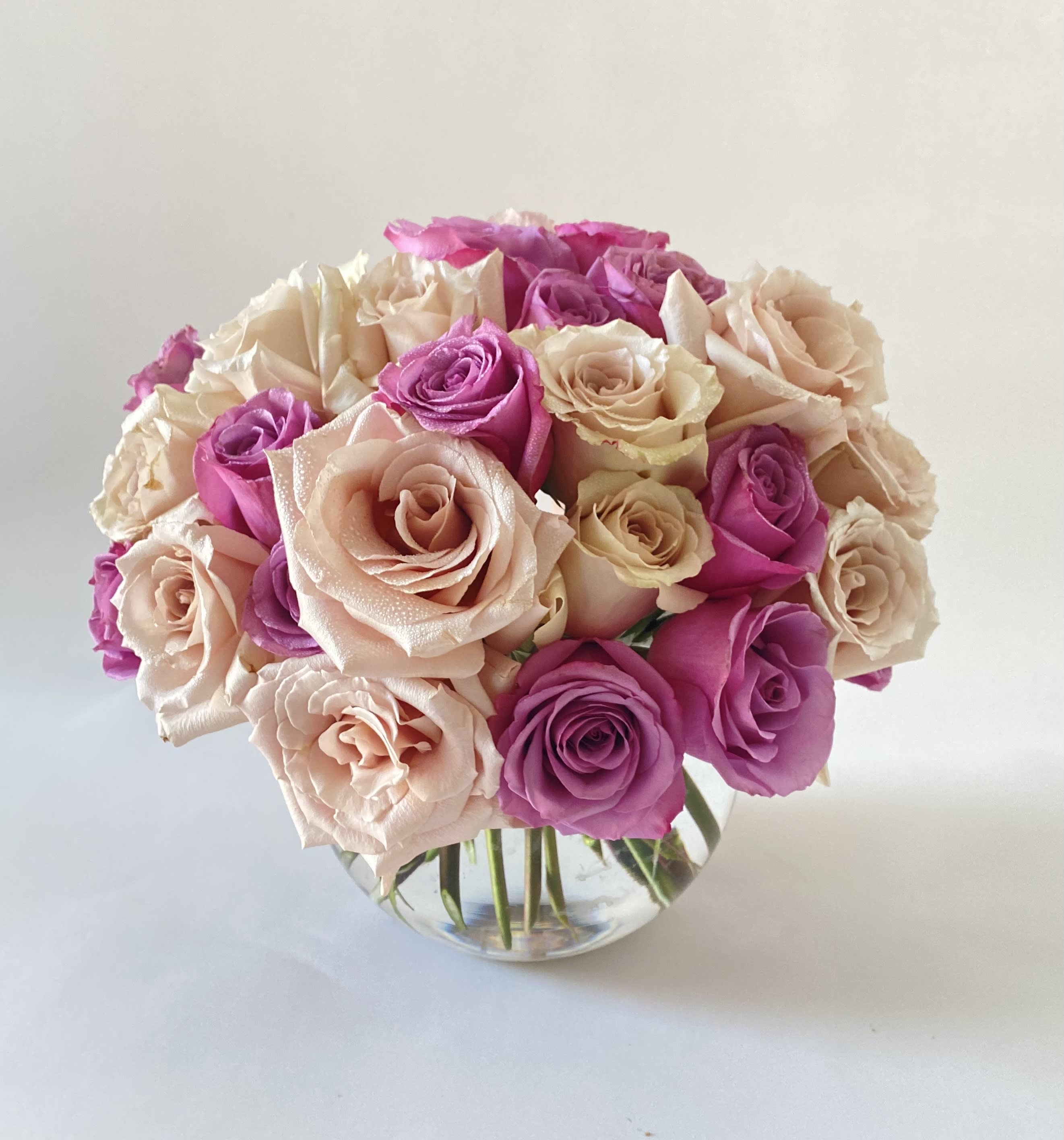 Bouquet of pink and blush roses in a clear glass vase