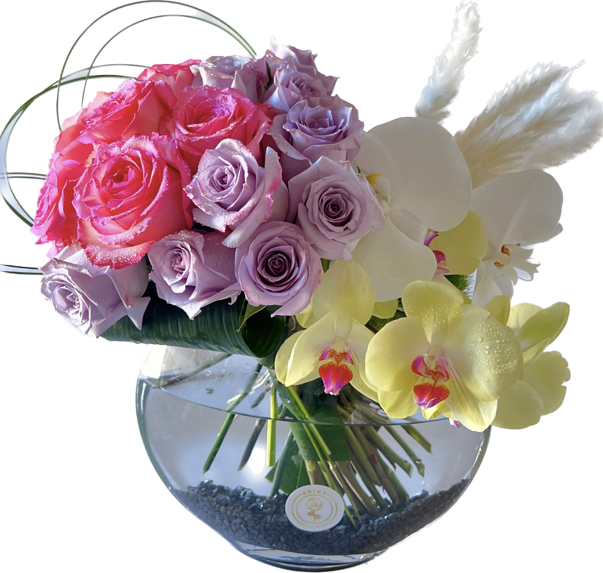 Pink and lavender roses with white orchids in a glass vase
