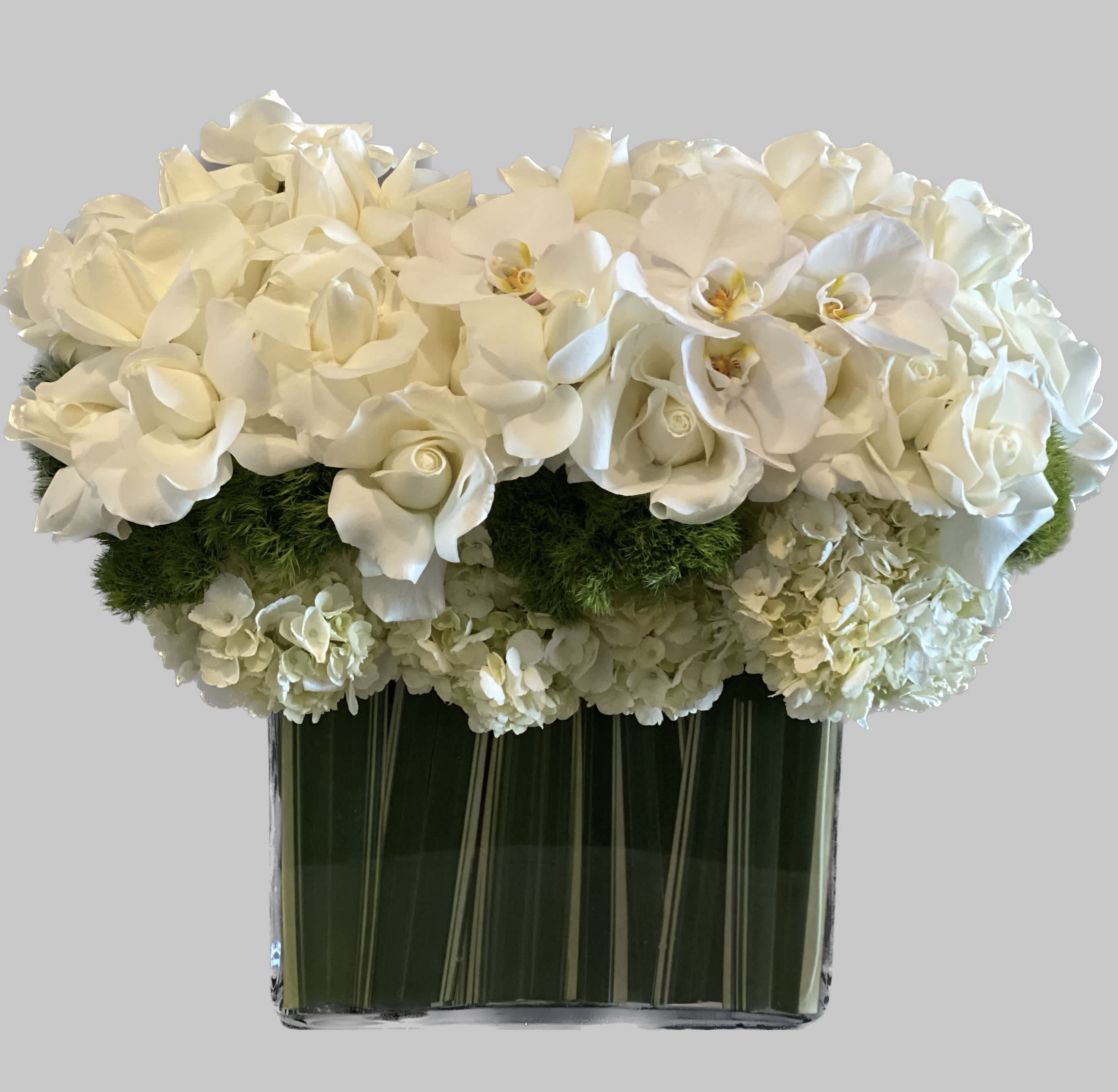 White floral arrangement in a clear rectangular vase