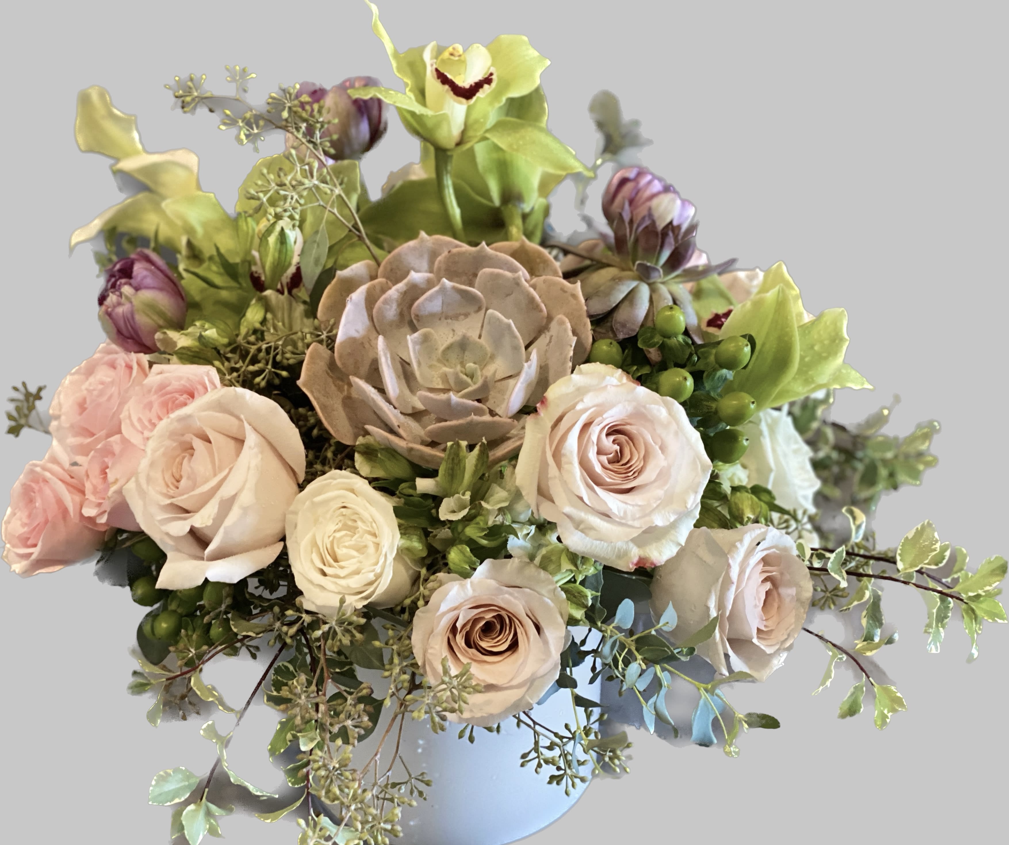 Bouquet of pale roses and green orchids in a light blue vase