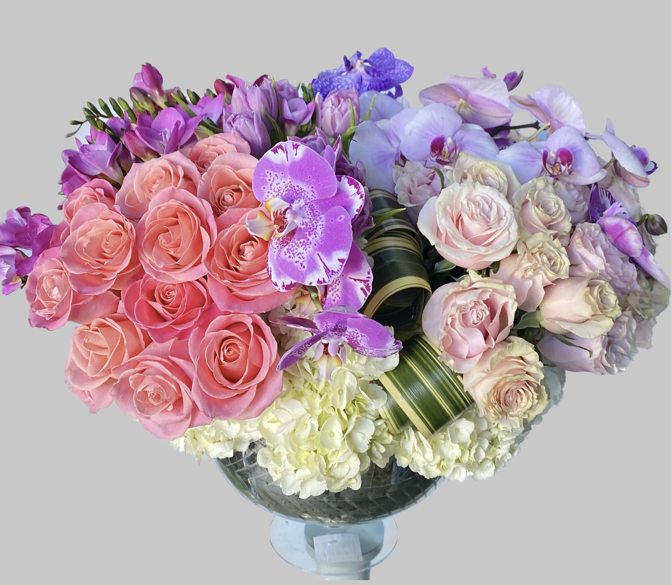 Bouquet of pink roses and purple orchids in a glass vase