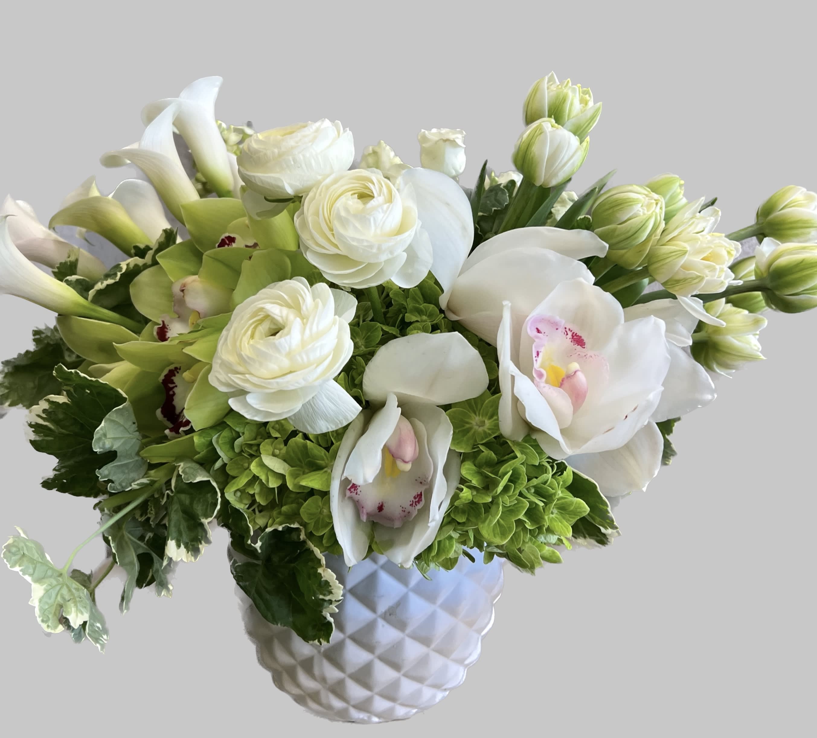 White and green floral arrangement in a textured white vase