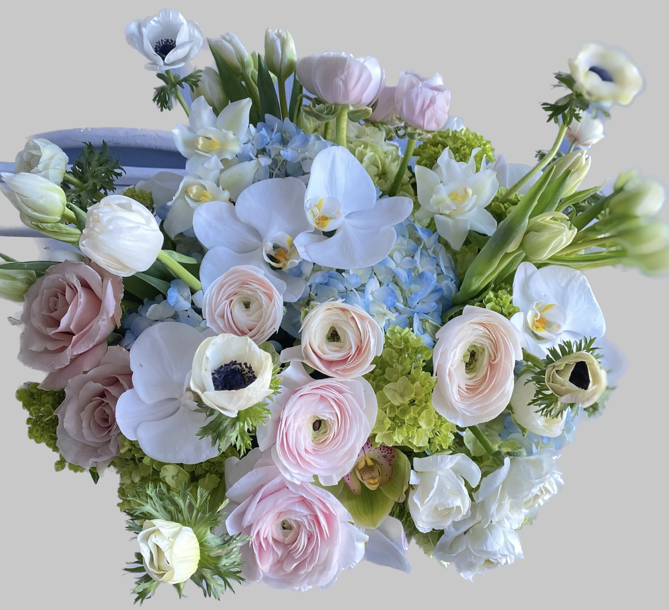 Pastel bouquet with white orchids, pink ranunculus, and pale roses