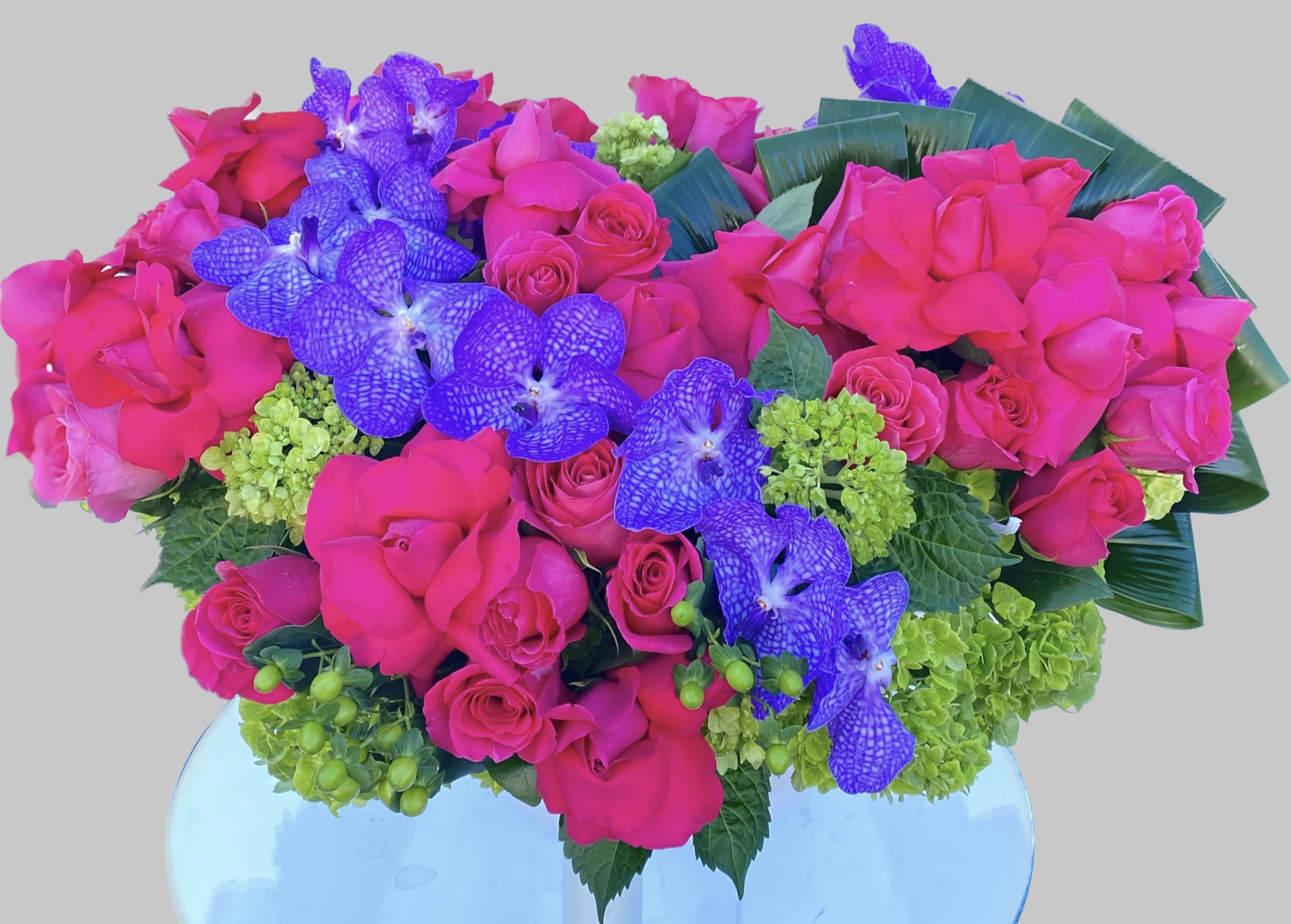 Pink roses and purple orchids arranged in a vase