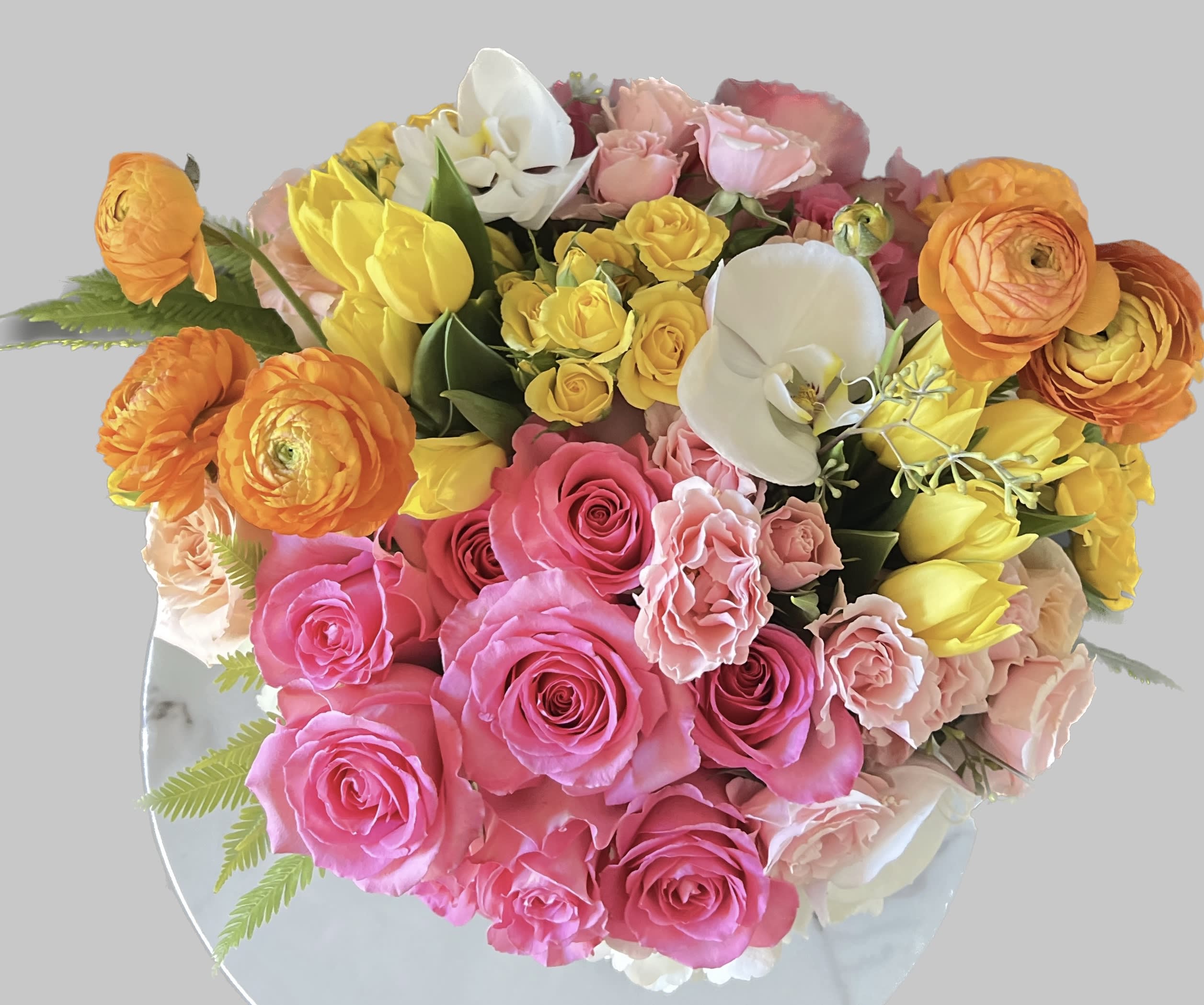 Bouquet of pink, yellow, orange, and white flowers on a round mirror