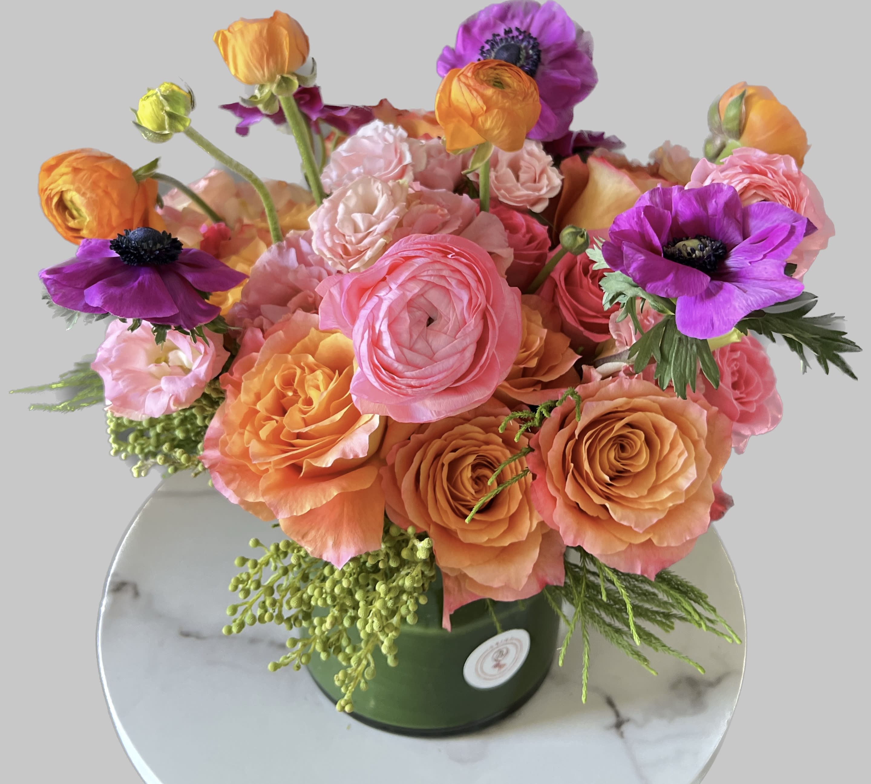 Bouquet of pink, orange, and purple flowers in a green vase