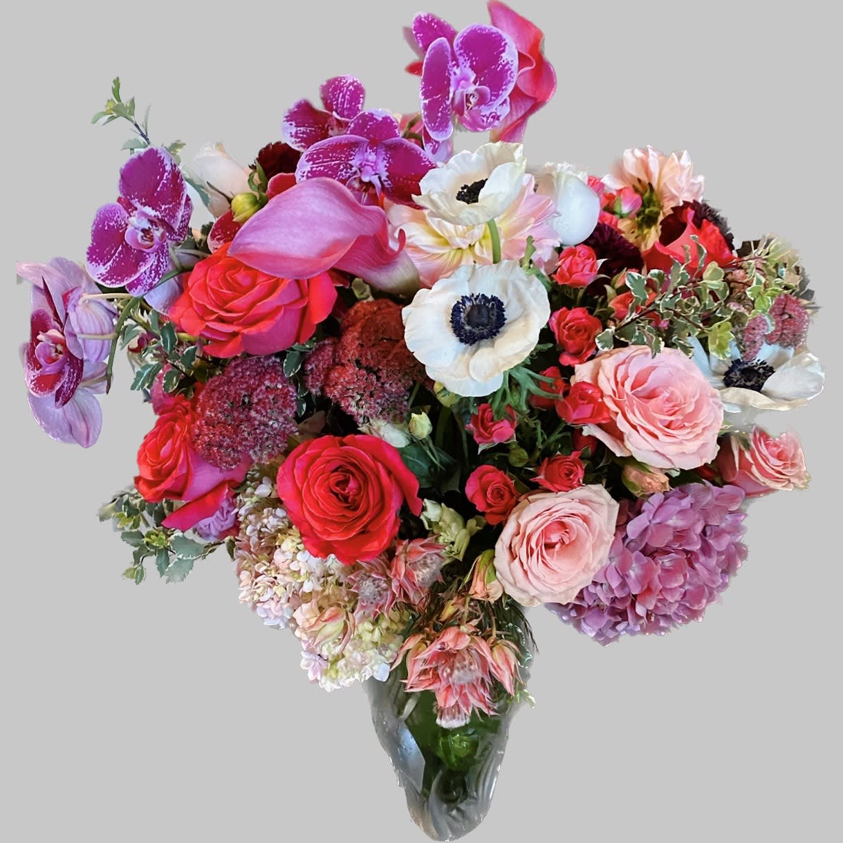 Large bouquet of pink, white, and purple flowers in a clear vase