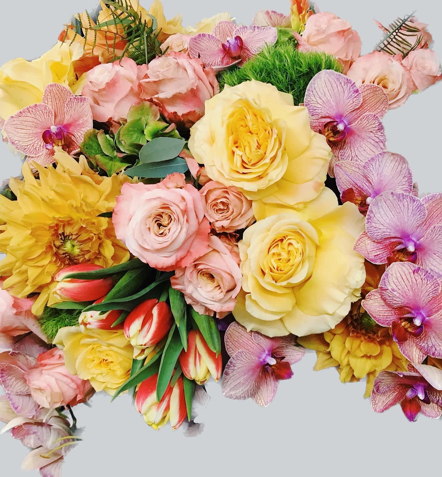 Mixed bouquet of yellow and pink roses with orchids and tulips