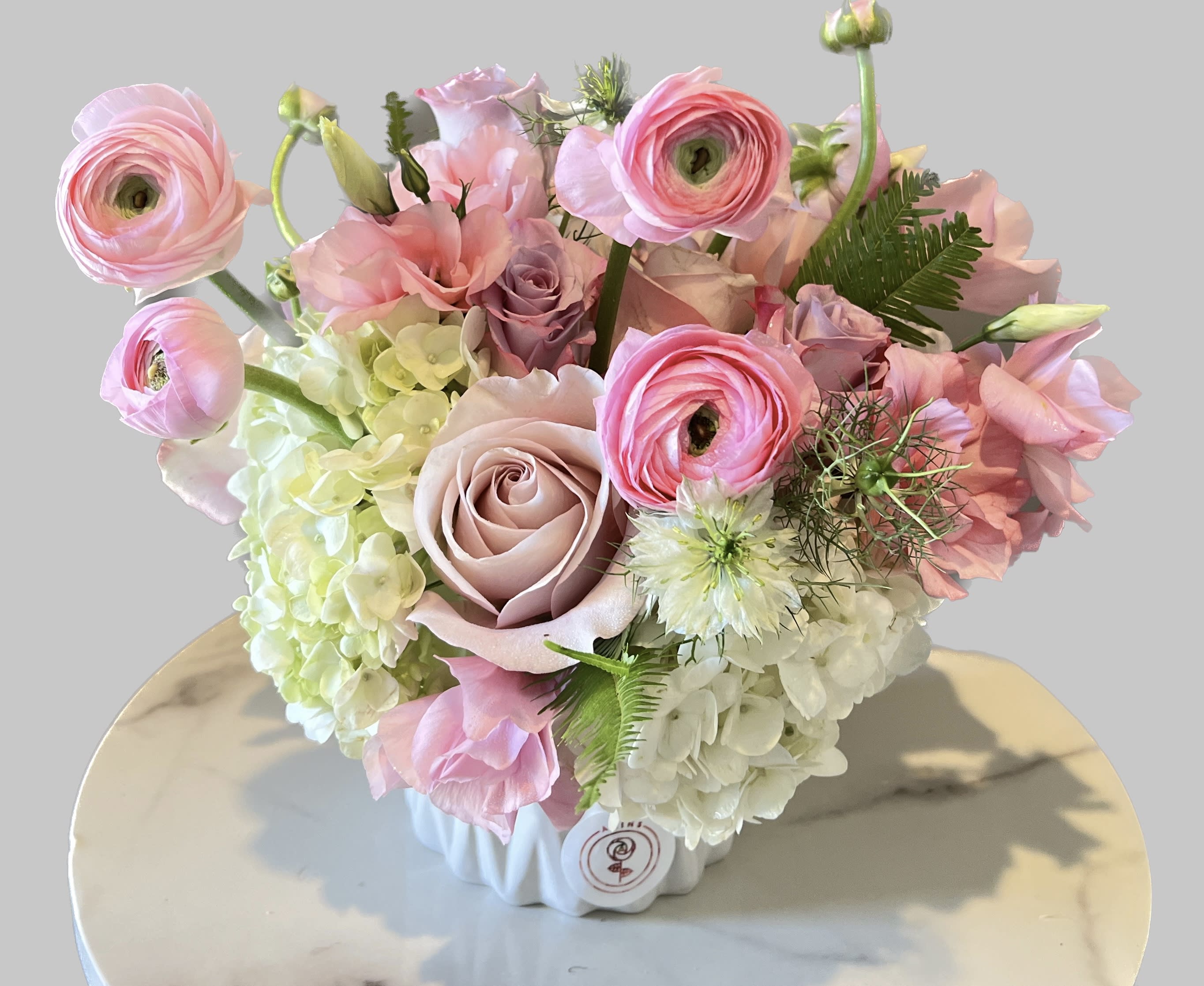 Pink and white floral arrangement in a white vase