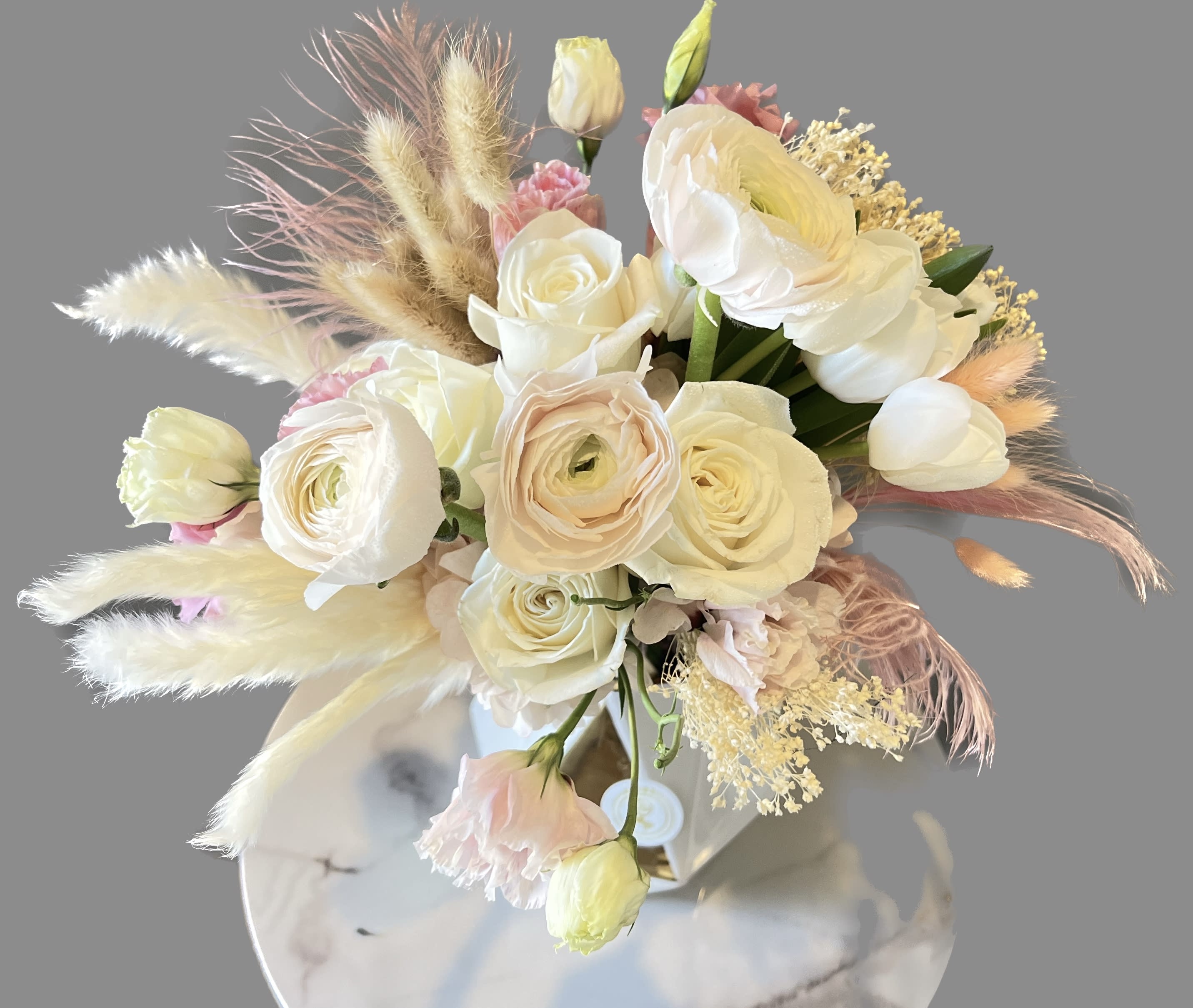 Cream and blush bouquet with roses and ranunculus in a vase