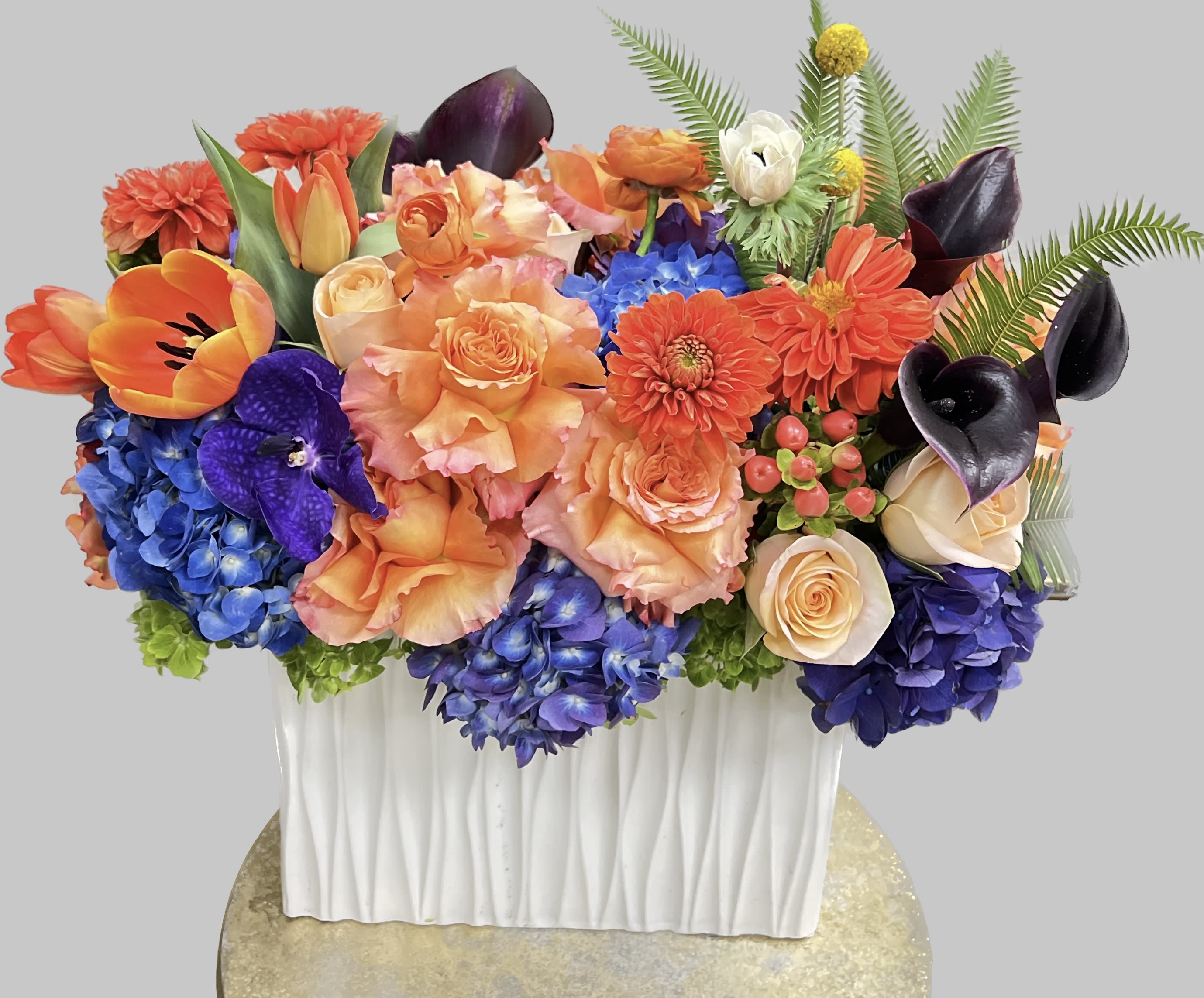 Colorful floral arrangement in a white rectangular vase