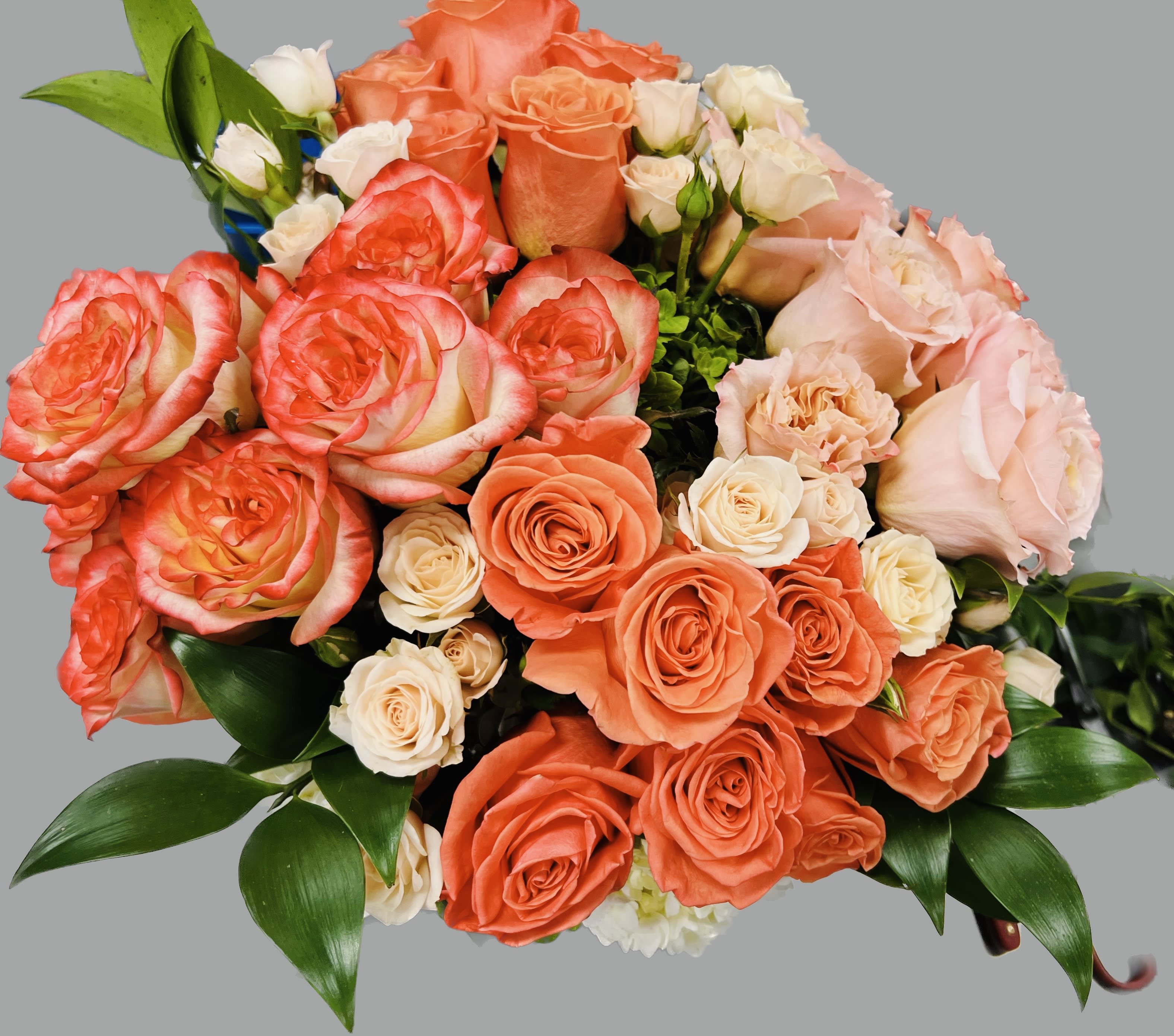Bouquet of coral and blush roses with white spray roses