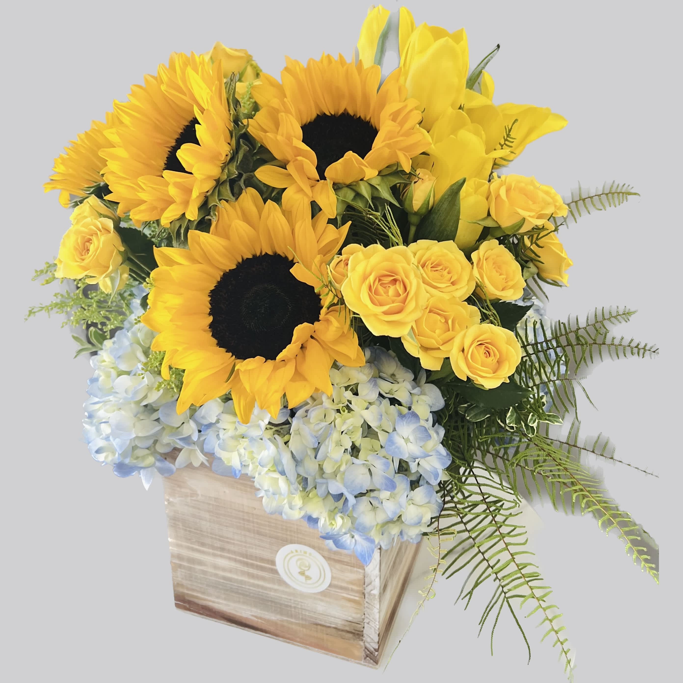 Cutie Pie  - Send this to the cutie in your life! Great for a new baby, a birthday, or just cheering somebody up! This summertime arrangement with sunflowers, tulips, and yellow roses lights up any space.  Approximate Dimensions: 15"D x 13"H