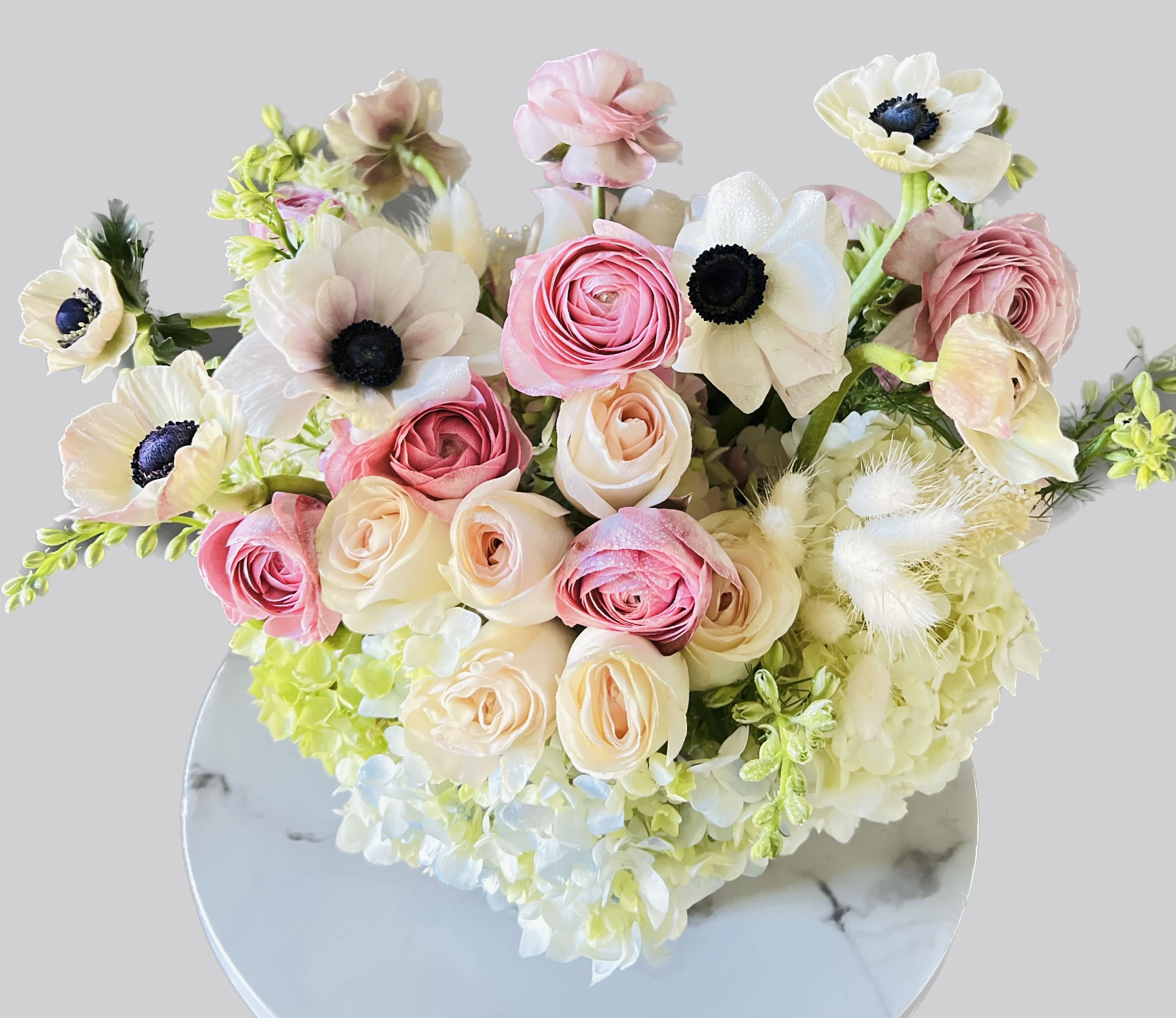 Bouquet of pink and cream flowers with white blooms in a round vase