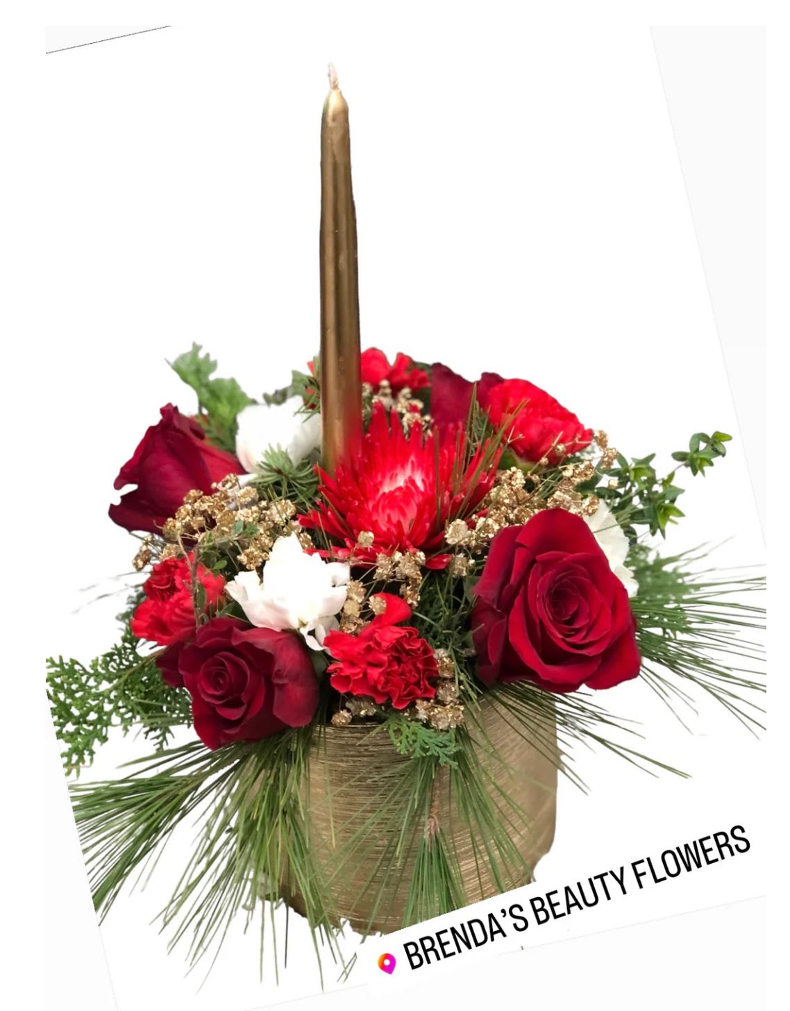 Gold ceramic single candle centerpiece  - Get your home in the holiday spirit with this holiday centerpiece that will look wonderful on your dining room table or on the mantle over a roaring fire in the fireplace. Red flowers, white poms, and more give this arrangement a little magical touch.  