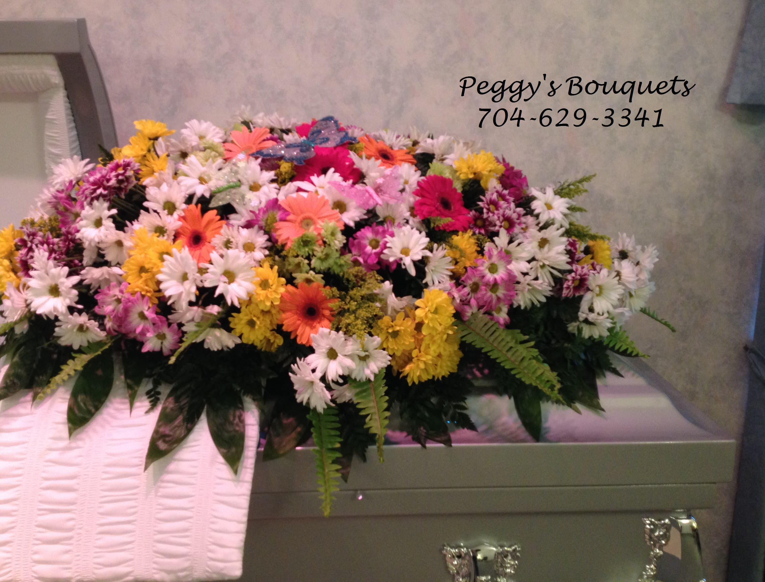 Colorful mixed flower casket spray with daisies and gerbera daisies