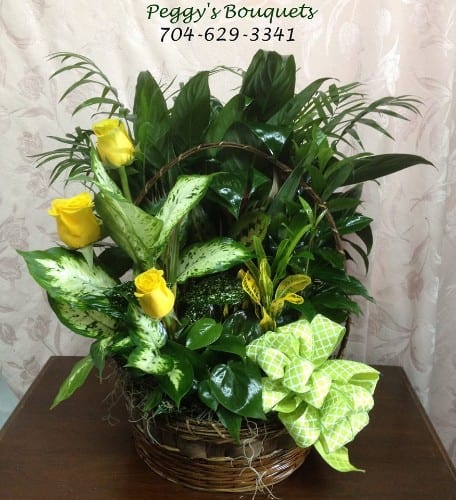 Basket arrangement with yellow roses and assorted green foliage