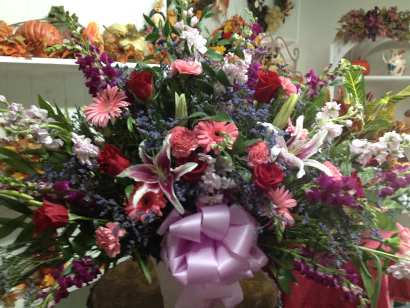 Large mixed bouquet with roses, lilies, and pink gerbera daisies in a vase