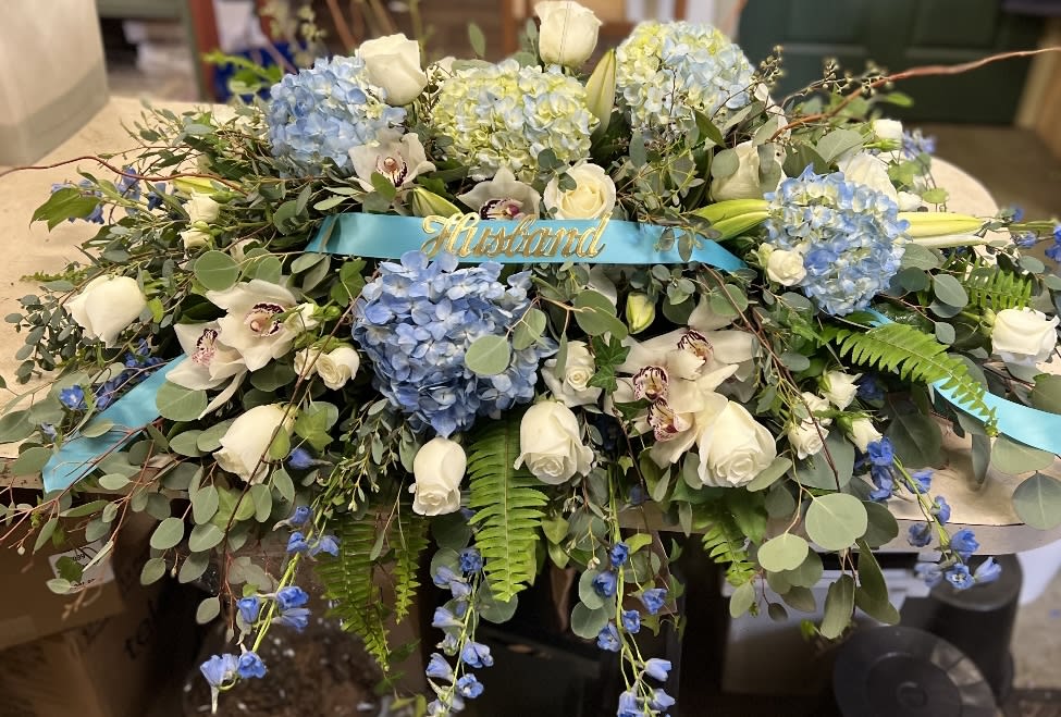 Large blue and white floral arrangement with a blue ribbon