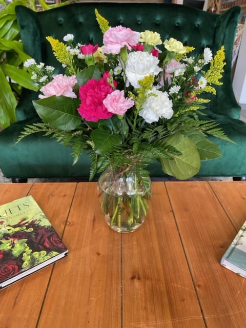 Mixed pink and white carnations in a clear glass vase