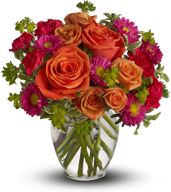 Bouquet of orange roses and magenta daisies in a clear glass vase