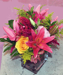 Pink lilies and a yellow rose in a glass vase