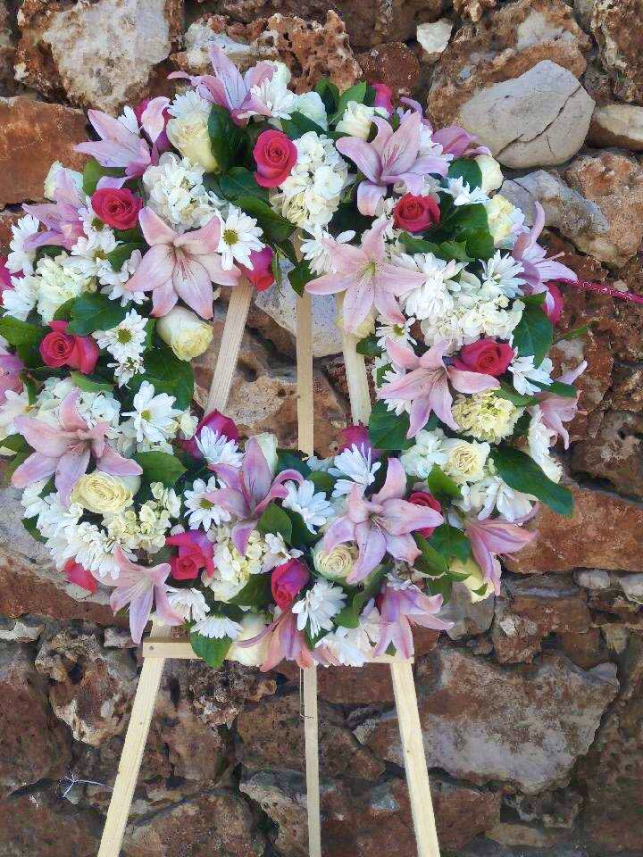 Heart-shaped floral wreath with pink lilies, roses, and white daisies