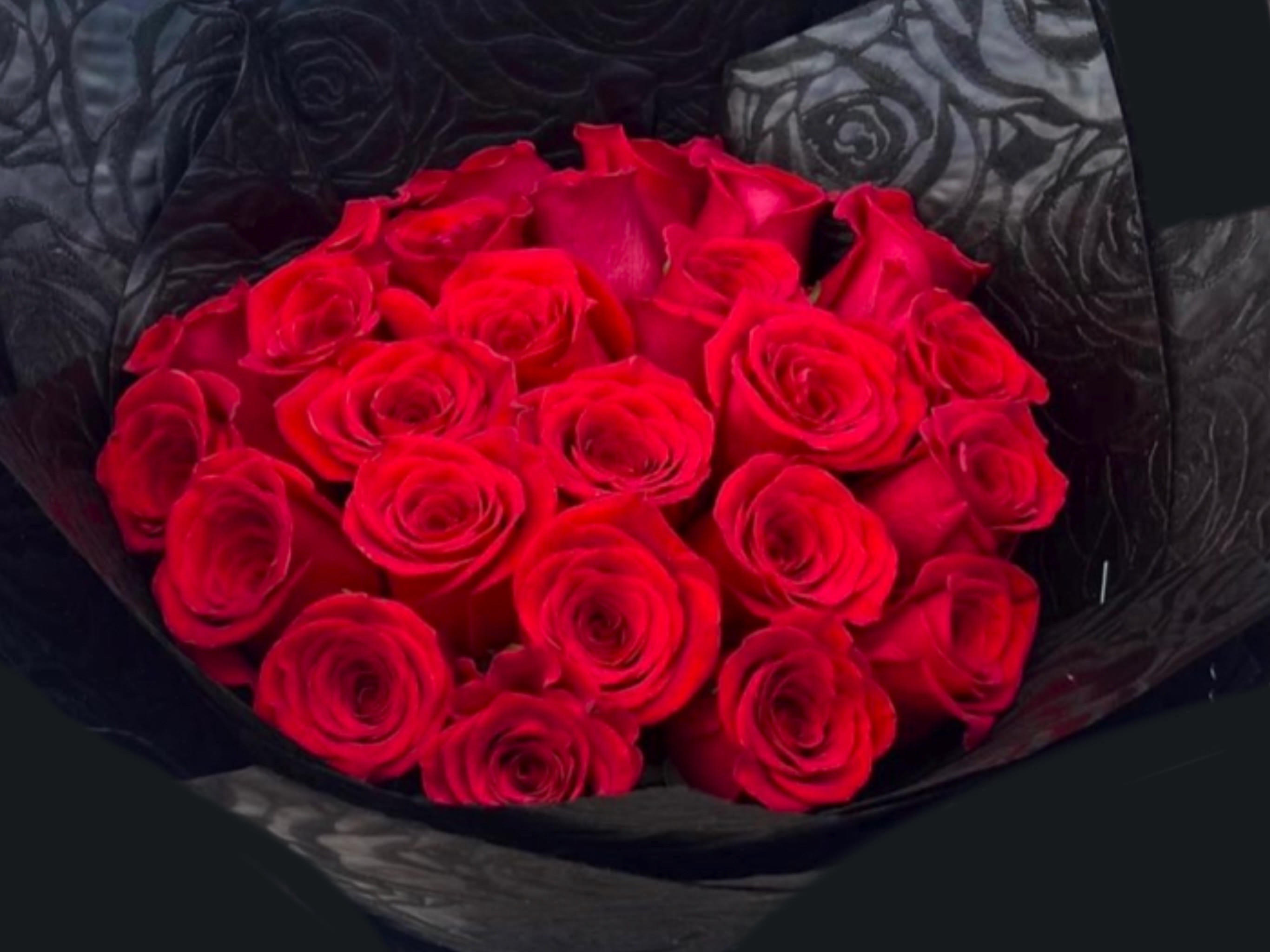 Bouquet of red roses wrapped in black paper