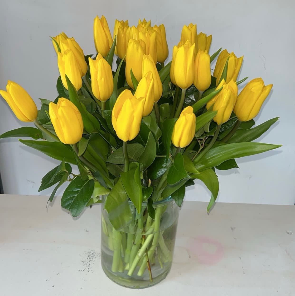 Yellow tulips arranged in a clear glass vase